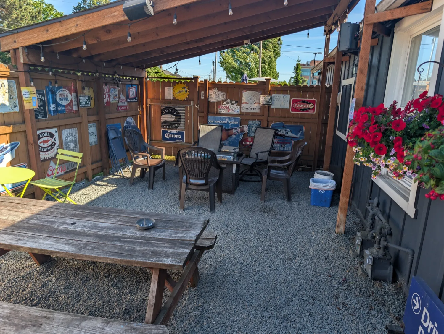 Covered back patio with picnic tables, string lights and vintage beer signs
