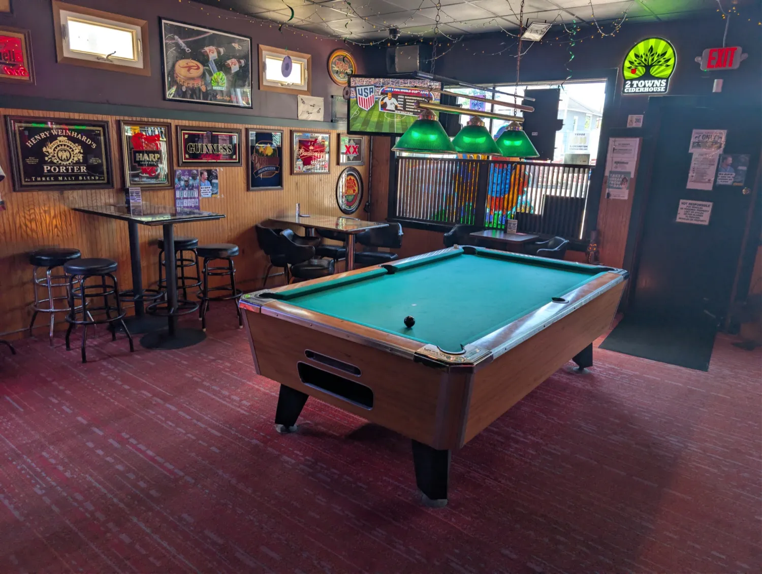 Pool table under green lamps at The Fireplace